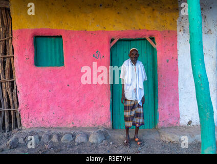 Ritratto di un vecchio etnia afar uomo davanti a una casa rosa, regione di Afar, Afambo, Etiopia Foto Stock