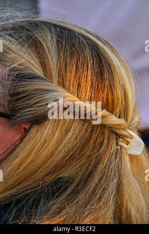 Treccia di capelli biondi su una giovane donna come visto dalla parte posteriore della sua testa close up Foto Stock