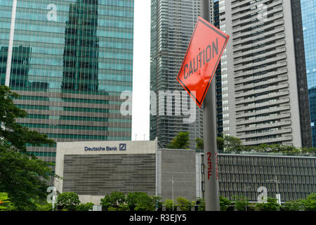 Singapore - 16 Settembre 2017: "Attenzione" strada segno accanto alla Deutsche Bank segno nella costruzione di uffici nel quartiere centrale degli affari di Singapore con n. Foto Stock