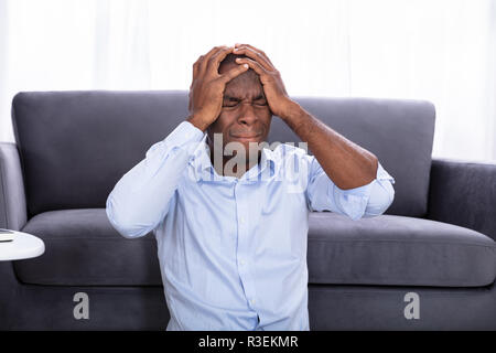 Ritratto di un orinato Africano di toccare la sua testa Foto Stock