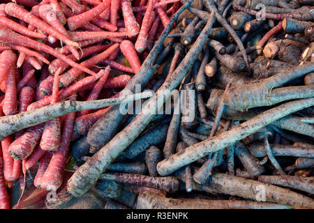 Vista sopra una miscela di fresche raccolte carote crude viola e rosse in un mercato di produzione di agricoltori locali a Jaipur, Rajasthan, India Foto Stock