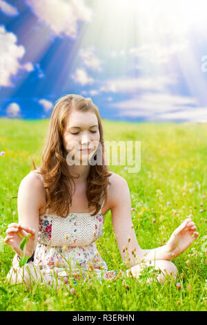 Giovane donna meditando in natura Foto Stock