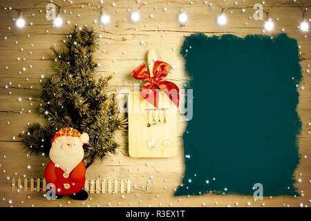 Divertimento sfondo per il menu o ricette di Natale. Fir, Babbo Natale e gli utensili da cucina con sfondo nero per scrivere Foto Stock