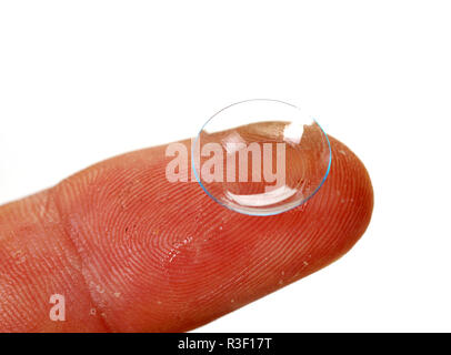 Lente a contatto sul dito con sfondo bianco, vista ravvicinata. Medicina e vision concept Foto Stock