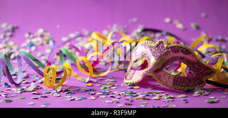 Festa di carnevale. Oro rosa maschera, stelle filanti e coriandoli su sfondo  viola, banner Foto stock - Alamy