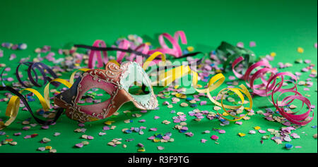 Festa di carnevale. Oro viola maschera, stelle filanti e coriandoli  luminosi su sfondo rosa, banner Foto stock - Alamy