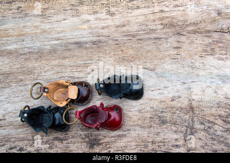 Colorfull portachiavi in pelle a forma di scarpa vecchia su sfondo di legno Foto Stock