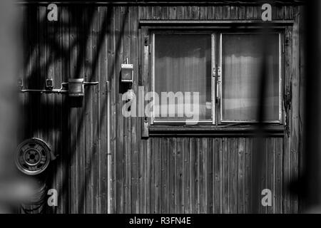 Una facciata con finestre di una piccola casa in legno in bianco e nero, Kil, Svezia Foto Stock