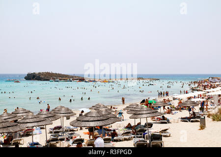 I villeggianti di relax al sole sulla spiaggia di Nissi, Ayia Napa, Cipro Foto Stock