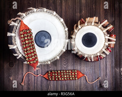 Il Tabla tamburi e campane per danze indiane su sfondo di legno Foto Stock