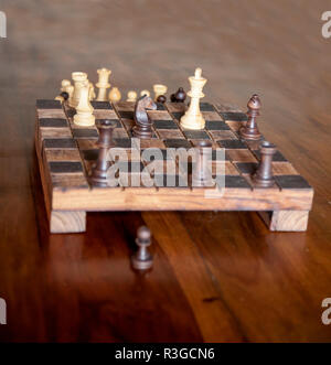 Gioco di scacchi su fatti a mano in legno rustico scacchiera Foto Stock