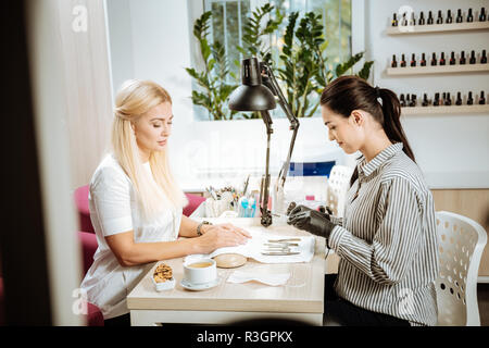 Bella elegante bionda imprenditrice avente la sua manicure fatto Foto Stock