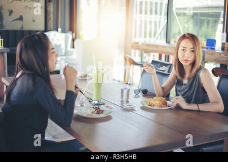 Due giovani amici di sesso femminile ridere e a pranzo insieme al ristorante Foto Stock