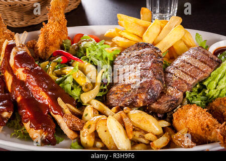 Enorme barbecue piastra con misto di carne e bistecche Foto Stock