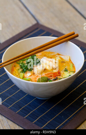 Piastra della shell di cucinato al momento tom yam zuppa di aragosta e il coriandolo Foto Stock