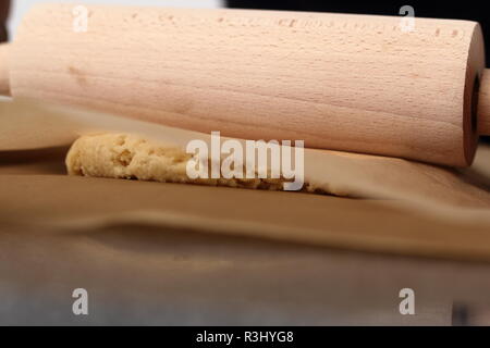 Il roll out pasta tra due fogli di carta da forno . Rendendo il sidro di mele serie a torta. Foto Stock