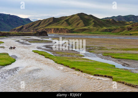 Due cavalieri e quattro ruote vettura che attraversa un fiume, Kurumduk valley, provincia di Naryn, Kirghizistan Foto Stock