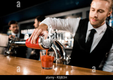 Barman drink di versatore in vetro sul contatore di legno Foto Stock