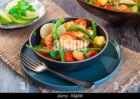 Thai di gamberi con ananas e fagioli verdi su tavola in legno rustico Foto Stock