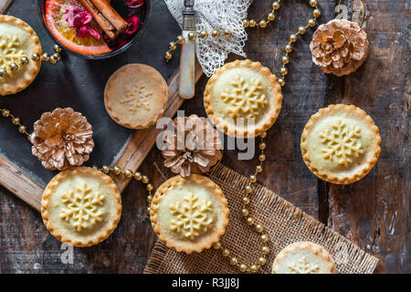 Natale tradizionale pasticci di carne macinata e vin brulé sul tavolo di legno - vista superiore Foto Stock