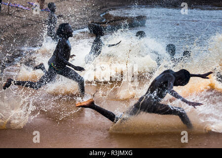 I ragazzi corrono al fiume Omo, Etiopia Foto Stock