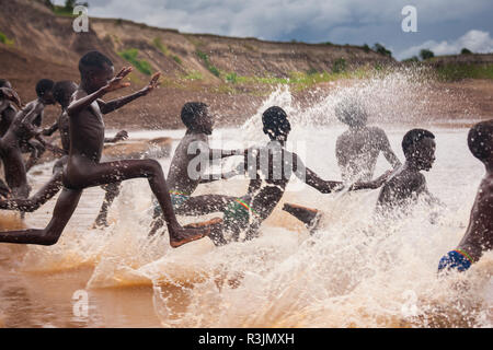 I ragazzi corrono al fiume Omo, Etiopia Foto Stock