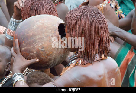 Hamar tribù, popolo di bere vino a bovini Jumping (un evento cerimoniale di celebrare un Hamar uomo arriva di età) in Hamar Village, Sud Omo, Etiopia Foto Stock