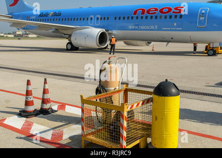 Massa di apparecchiature di sicurezza in aeroporto il grembiule a Verona, Italia. Un Boeing 737 è in background. Foto Stock