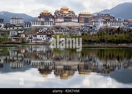 La Cina, nella provincia dello Yunnan, Northwestern Yunnan, Shangri-La, monastero Songzanlin. Il monastero di alba riflessa nel lago sacro. Foto Stock