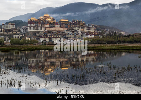 Asia, Cina, nella provincia dello Yunnan, Shangri-la, monastero Songzanlin. Il monastero di alba riflessa nel lago sacro. Foto Stock