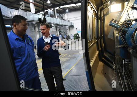 (181123) -- LANZHOU, nov. 23, 2018 (Xinhua) -- Stephan Mueller colloqui con il suo collega nella propria fabbrica a Lanzhou, capitale della Cina nord-occidentale della provincia di Gansu, Ottobre 23, 2018. Stephan, 48, è venuto in Cina per lavorare come un espatriato dalla Germania nel 2006, e 4 anni più tardi egli aveva la sua propria casa in Cina dopo che si è sposato con una moglie cinese. Negli anni successivi, ha viaggiato in Cina con sua moglie, reso più amici e imparato di più circa la società cinese. (Xinhua/Chen Bin) (clq) Foto Stock