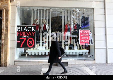 Salonicco, Grecia, Novembre 23rd, 2018. Una donna cammina davanti a un negozio in Salonicco Tsimisky street sul Venerdì nero. Venerdì nero shopping è stata per lungo tempo un post-tradizione del ringraziamento negli Stati Uniti, ma in Grecia è un importato di recente tradizione, e questo anno dettaglianti greci hanno esteso in "nero settimana". Credito : Orhan Tsolak / Alamy Live News Foto Stock