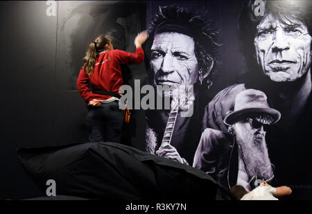 Gronau, Germania. Xxi Nov, 2018. In 'rock'n'popmuseum' un membro dello staff di bastoni un poster della band Rolling Stones con i membri della band Keith Richards e Mick Jagger (r) su una parete. In Europa il primo rock e pop museo nella regione di Münsterland apre le sue porte ai visitatori di nuovo il 25 novembre. Nove aree tematiche sono state impostate, dedicata ad aspetti quali la moda come ribellione. (A DPA: 'Rock'n'Pop-Museum Gronau: Un anno di ricostruzione' dal 23.11.2018) Credito: Ina Fassbender/dpa/Alamy Live News Foto Stock