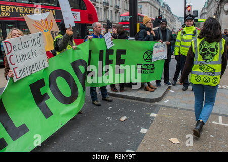 Londra, Regno Unito. 23 ott 2018. Il nodo stradale a Oxford Circus è bloccato per un paio di minuti in un tempo come il Black friday shoppers ottenere su con i loro acquisti e polizia rimanere rilassato. La Ribellione di estinzione - co ospitato da salendo, 'ribelle contro il governo britannico per Inazione penale a fronte del cambiamento climatico catastrofe e il collasso ecologico". Una protesta che coinvolge strade di bloccaggio in tutta Londra per brevi periodi di tempo. Credito: Guy Bell/Alamy Live News Foto Stock