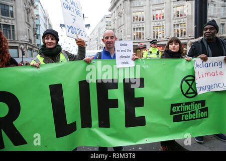 I manifestanti visto tenendo un enorme striscione durante la protesta. Estinzione della ribellione manifestanti blocco Oxford Street junction tenendo premuto il traffico sul Venerdì nero giorno delle vendite. Foto Stock