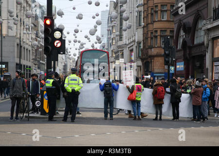 I manifestanti visto tenendo un enorme striscione durante la protesta. Estinzione della ribellione manifestanti blocco Oxford Street junction tenendo premuto il traffico sul Venerdì nero giorno delle vendite. Foto Stock