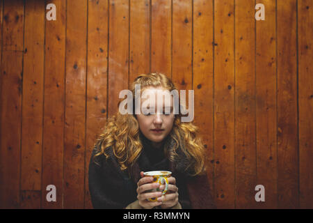 Donna che mantiene una tazza di caffè nella caffetteria Foto Stock