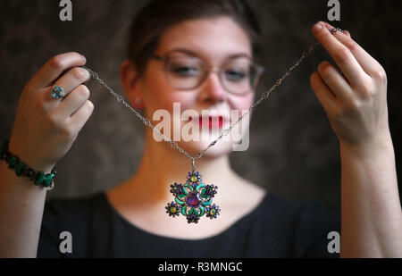 Casa d'Aste assistant Jaine Heggie prende uno sguardo più da vicino a un 1920s gem-set di arti e mestieri che pendente è visualizzato a Bonhams, Edimburgo, prima che venga offerto all'asta come parte della gioielleria e XX secolo foto vendita la prossima settimana. Foto Stock