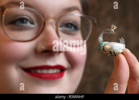 L'assistente della casa d'asta Jaine Heggie dà un'occhiata più da vicino ad una perla d'acqua dolce, gem-set e rombo brooch progettato come un cigno che indossa un coronet, valutato a £2,000-2,200, Che è esposto a Bonhams, Edimburgo, prima che sia offerto all'asta come parte della gioielleria e 20 ° secolo di vendita di immagini la prossima settimana. Foto Stock