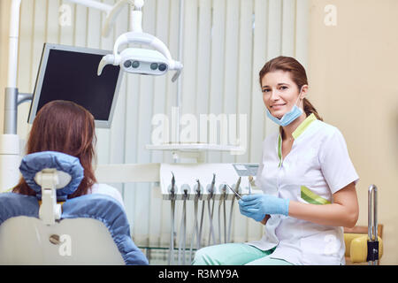 Donna sorridente dentista nello studio dentistico Foto Stock