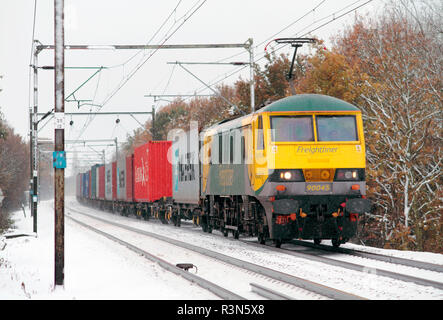 Una classe 90 locomotiva elettrica un lavoro freightliner servizio a una coperta di neve Margaretting in Essex. Foto Stock