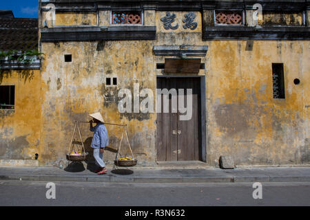 Venditore ambulante che porta i suoi frutti e verdure al mercato, Hoi An, Vietnam. (MR) Foto Stock