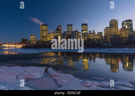 Inverno skyline della città si riflette nel fiume Bow a Calgary, Alberta, Canada Foto Stock