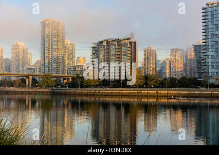 Kayakers gara da come lo skyline della città si riflette in False Creek in Vancouver, British Columbia, Canada Foto Stock