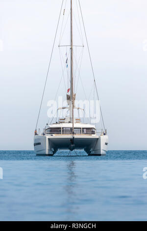 Un unico catamarano in mare aperto. Barca a vela nel Mediterraneo. Catamarano a vela barca vicino alla costa. Catamarano barca a vela ormeggiata in tropicale chiaro Foto Stock