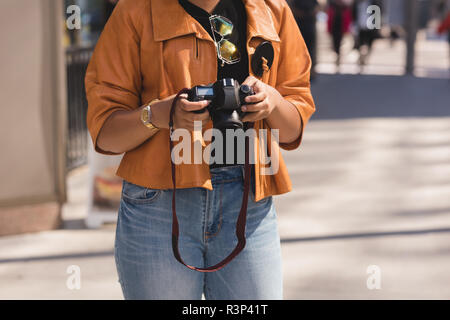 Donna rivedendo le foto sulla fotocamera Foto Stock