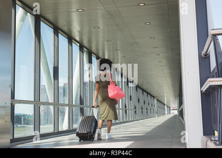 Donna con sacca bagagli a piedi all'aeroporto Foto Stock