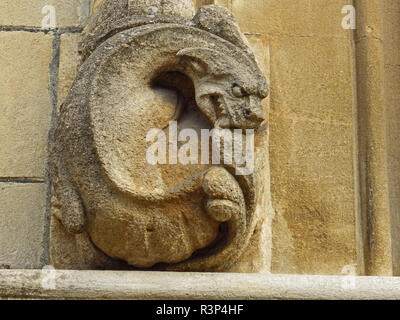 Un meteo usurato o dalle intemperie gargoyle di pietra o grottesco sulla parete di un College di Oxford parte dell'università in arenaria o calcare Foto Stock