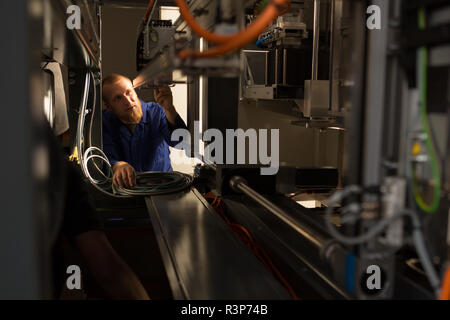 Ingegnere robotico lavorando in magazzino Foto Stock