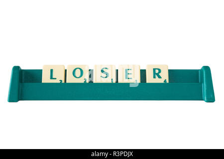 Gioco Scrabble lettera di piastrelle con valore di punteggio su un supporto formante la parola "perdente". Isolato su sfondo bianco. Foto Stock